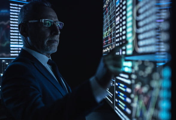 Trader interacting with data on multiple screens, illustrating scalable technology solutions and seamless integration for hedge funds.