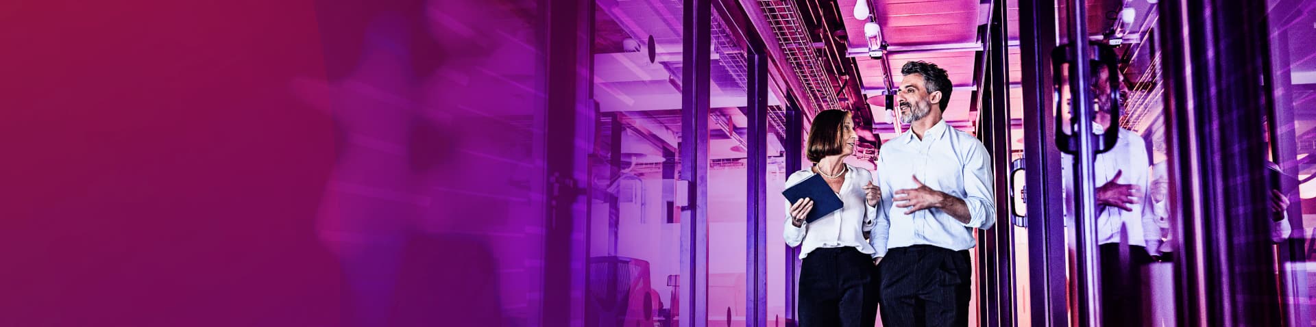 Two financial workers walking through office