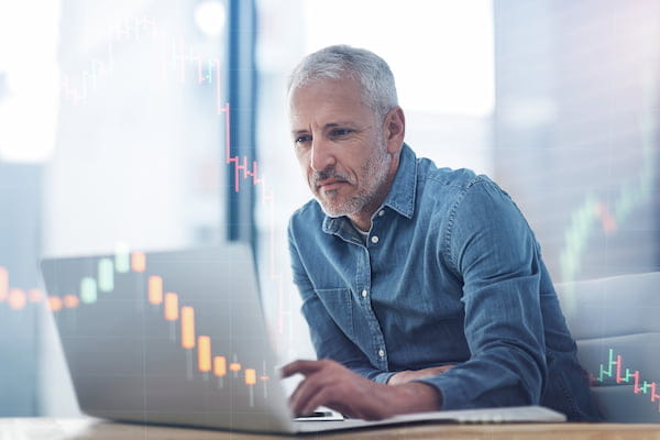 Trader on laptop by FOREX.com