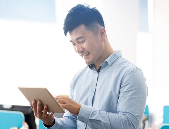 Man smiling as he looks at tablet