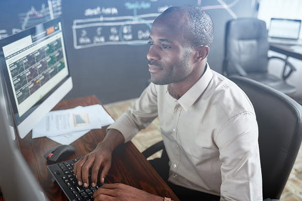 Man looking at financial data on monitor