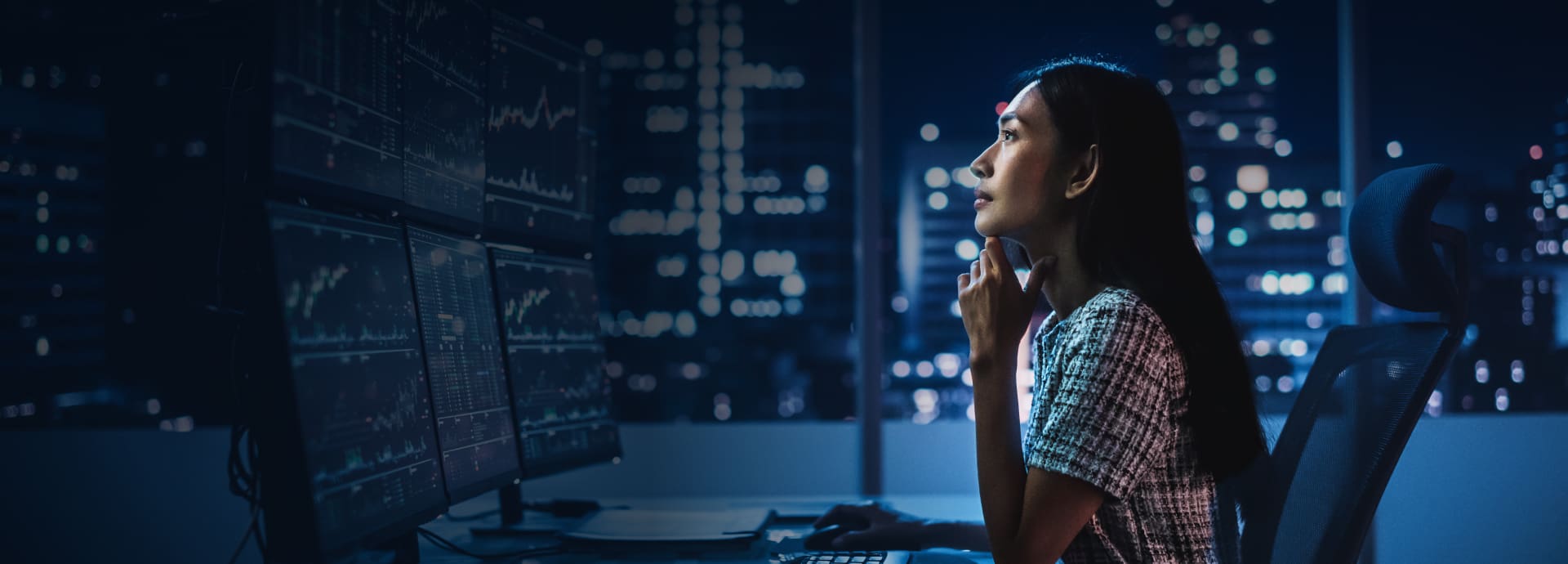 Trader analyzing data on multiple screens, representing StoneX Pro's advanced market access and FX trading solutions.